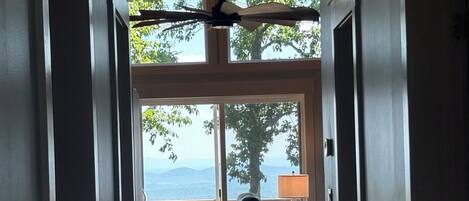 Ein Flur mit Deckenventilator, Blick ins Freie und einer Sitzecke mit Lampe.