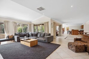 A spacious living room with a grey sofa, a wooden coffee table, and a dark rug. - Number 8 (Rye)