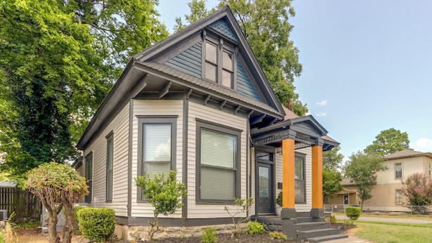 A two-story house with a gabled roof, large windows, and a front porch with steps. - Walk Everywhere! Downtown Fort Smith Duplex (Fort Smith)