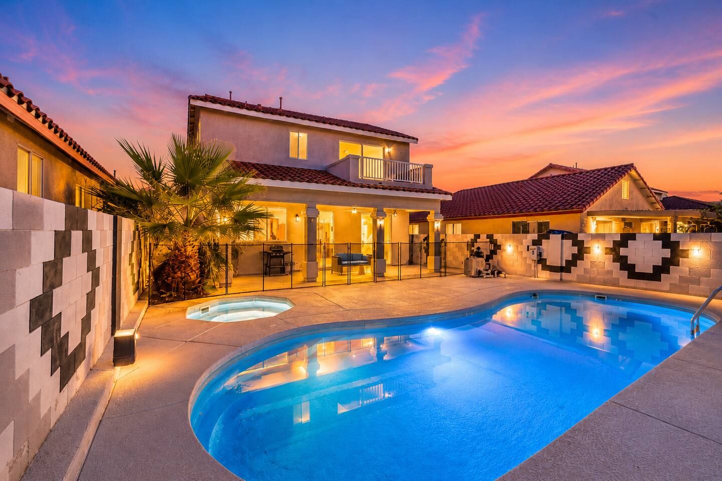 A residential property with a swimming pool, a two-story house with a balcony, and a patio area.