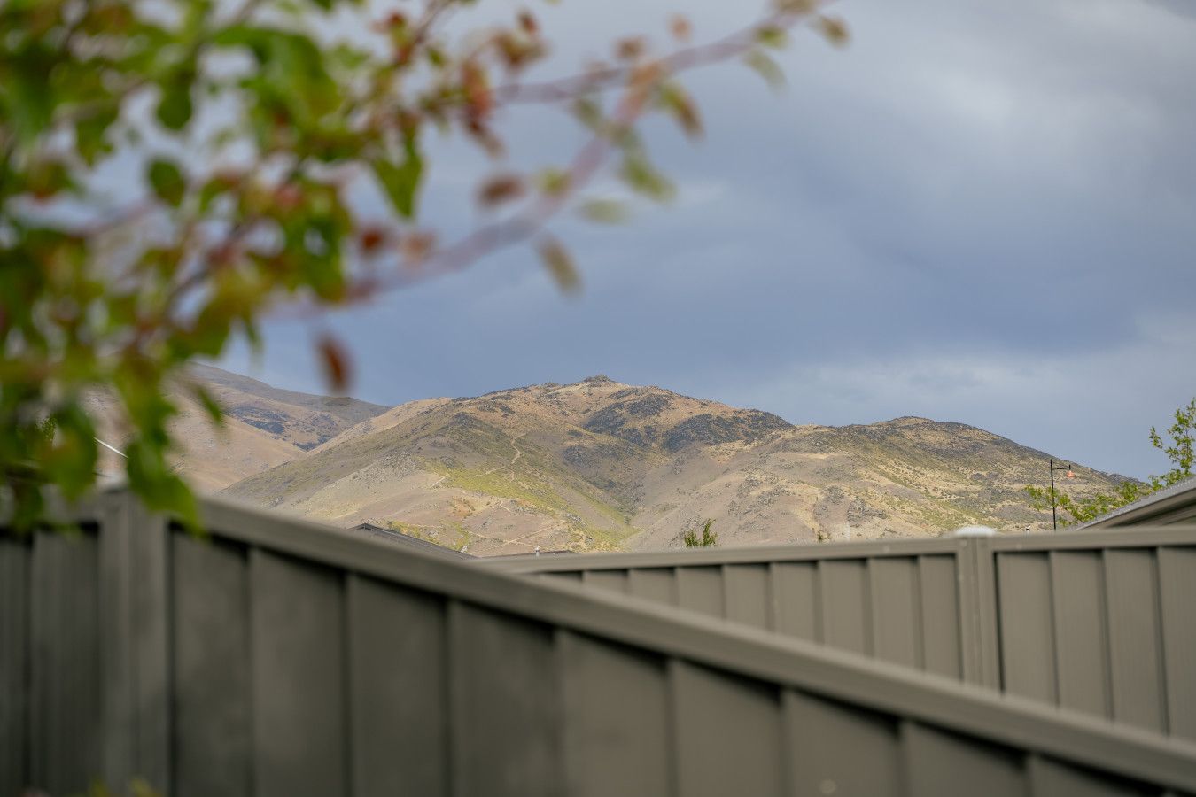 A mountain range with a wooden fence in the foreground.