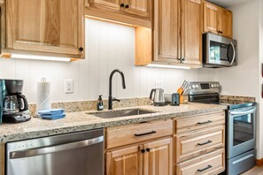 A kitchen with wooden cabinets, stainless steel appliances, a granite countertop, and a dishwasher. - 5 Beds, Sleeps 8, Walkable to Peak 8 Lifts, Free Bus Outside (Breckenridge)