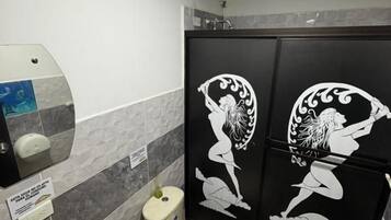 Un baño con inodoro, lavabo y decoración mural.