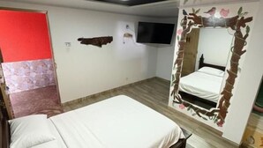 Une chambre à coucher avec un lit, un téléviseur fixé au mur et un élément décoratif original.