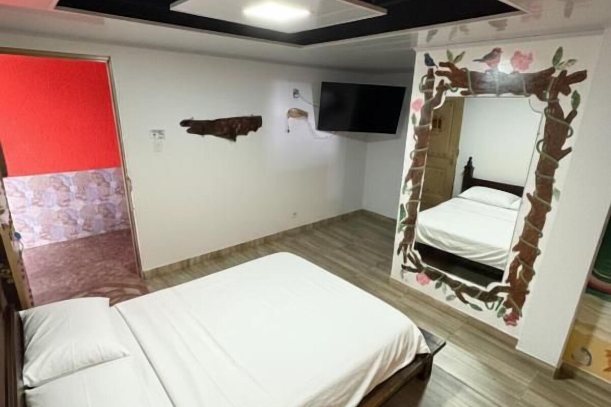 Quarto com cama, televisão na parede e uma decoração original.