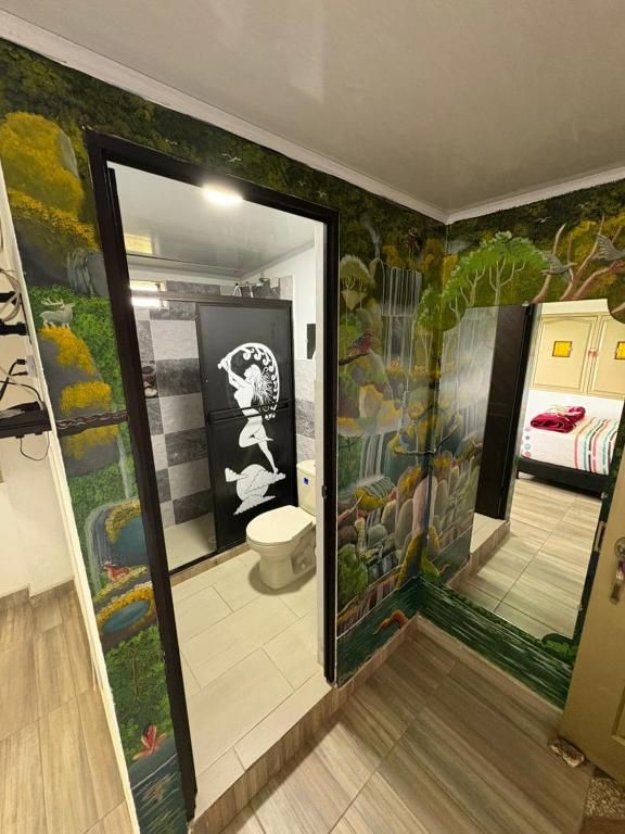 A bathroom with a mirror, toilet, and shower area.