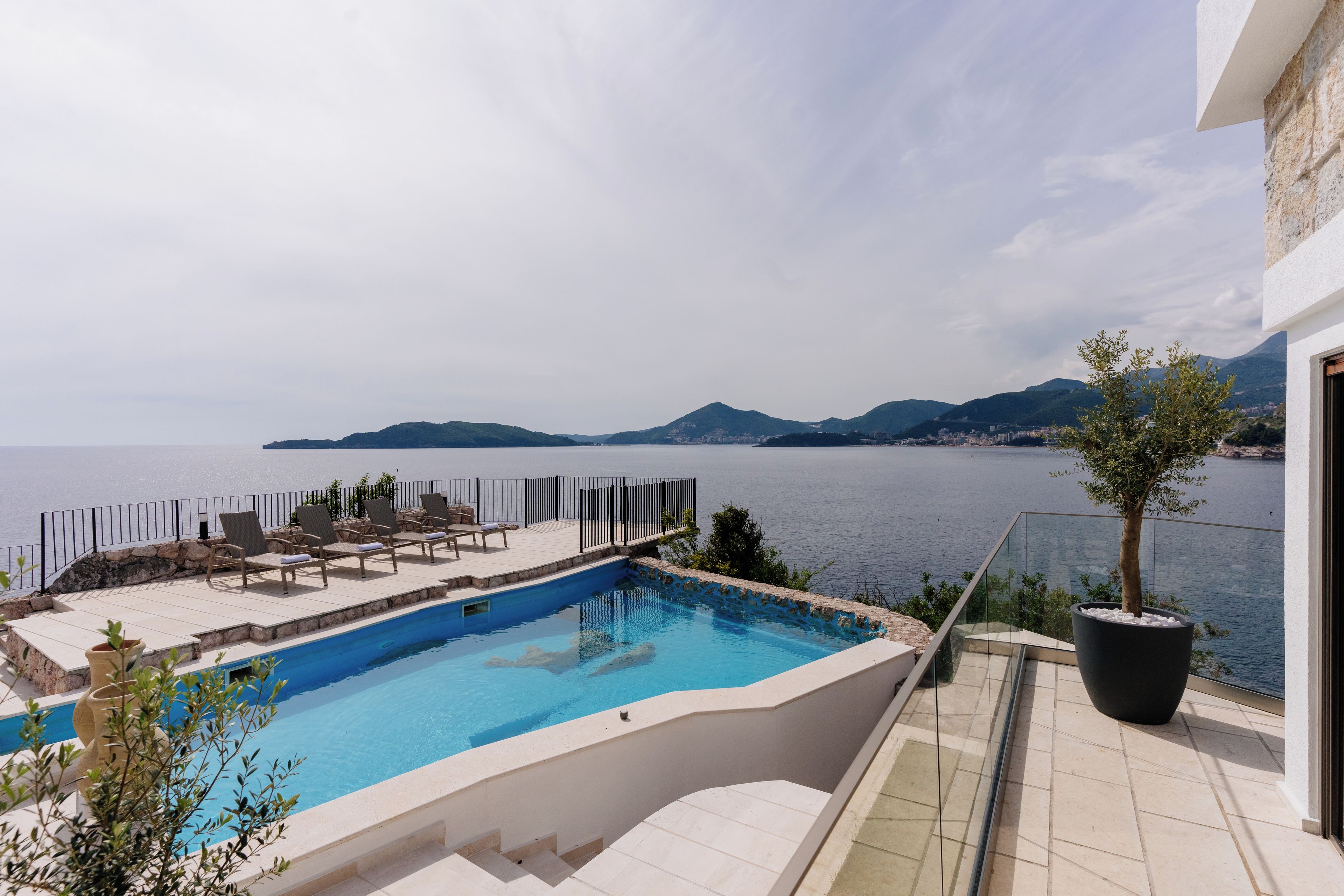 Una piscina privada con vistas al mar y a las montañas.