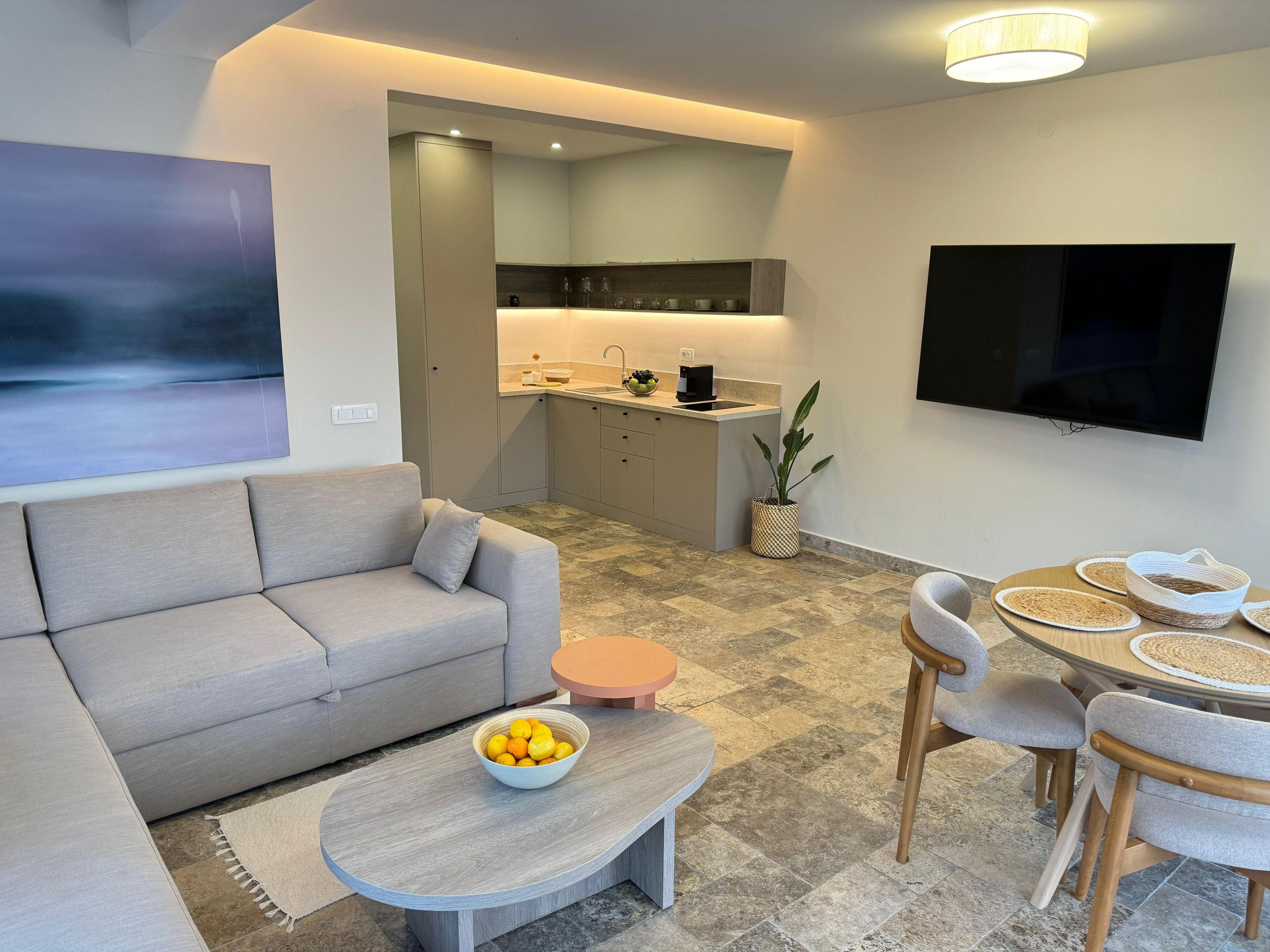 A modern living room with a sofa, coffee table, and dining area.
