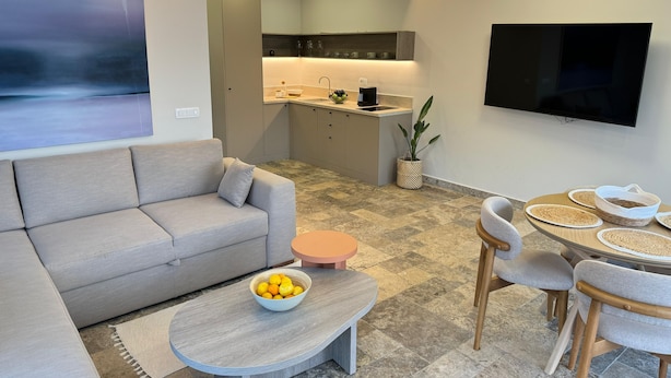 Una sala moderna con sofá, mesa de centro y comedor.