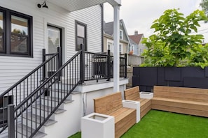 A residential property with a staircase, outdoor seating, and a green lawn. - Lux Chicago House with 6 Bedrooms / Garage / Yard / Game Room (Chicago)