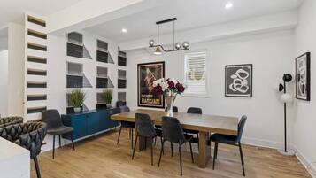 A modern dining area with a wooden table, black chairs, and a blue cabinet.