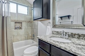 A bathroom with a bathtub, toilet, sink, and a shower area. - Spacious 2 BDRM I Central Austin I Hot Tub (Austin)