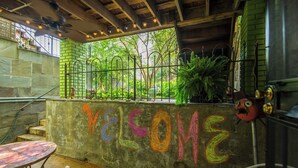 An outdoor seating area with a concrete wall featuring colorful graffiti, a metal fence, and potted plants. - Sojourn 1 Block to Metro, Cap Hill Garden Flat (Washington)