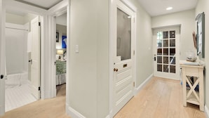A hallway with white doors leading to a bedroom and a bathroom. - Sojourn 1 Block to Metro, Cap Hill Garden Flat (Washington)