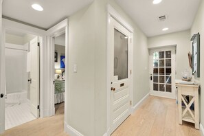 A hallway with white doors leading to a bedroom and a bathroom. - Sojourn 1 Block to Metro, Cap Hill Garden Flat (Washington)