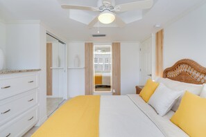 A bedroom with a bed, a ceiling fan, a wardrobe, and a window with curtains. - Redesigned Vanderbilt Beach Residence - Gulf & Sunset Views - Walk to Beach (Naples)