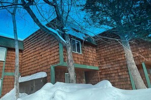 A wooden cabin with a shingled exterior, a front porch, and a snow-covered ground. - Upgraded Condo with Private Boat Dock - Ski Lease Available (South Lake Tahoe)
