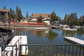 A marina with boats docked, a clear sky, and a building with a sloped roof in the background. - Upgraded Condo with Private Boat Dock - Ski Lease Available (South Lake Tahoe)