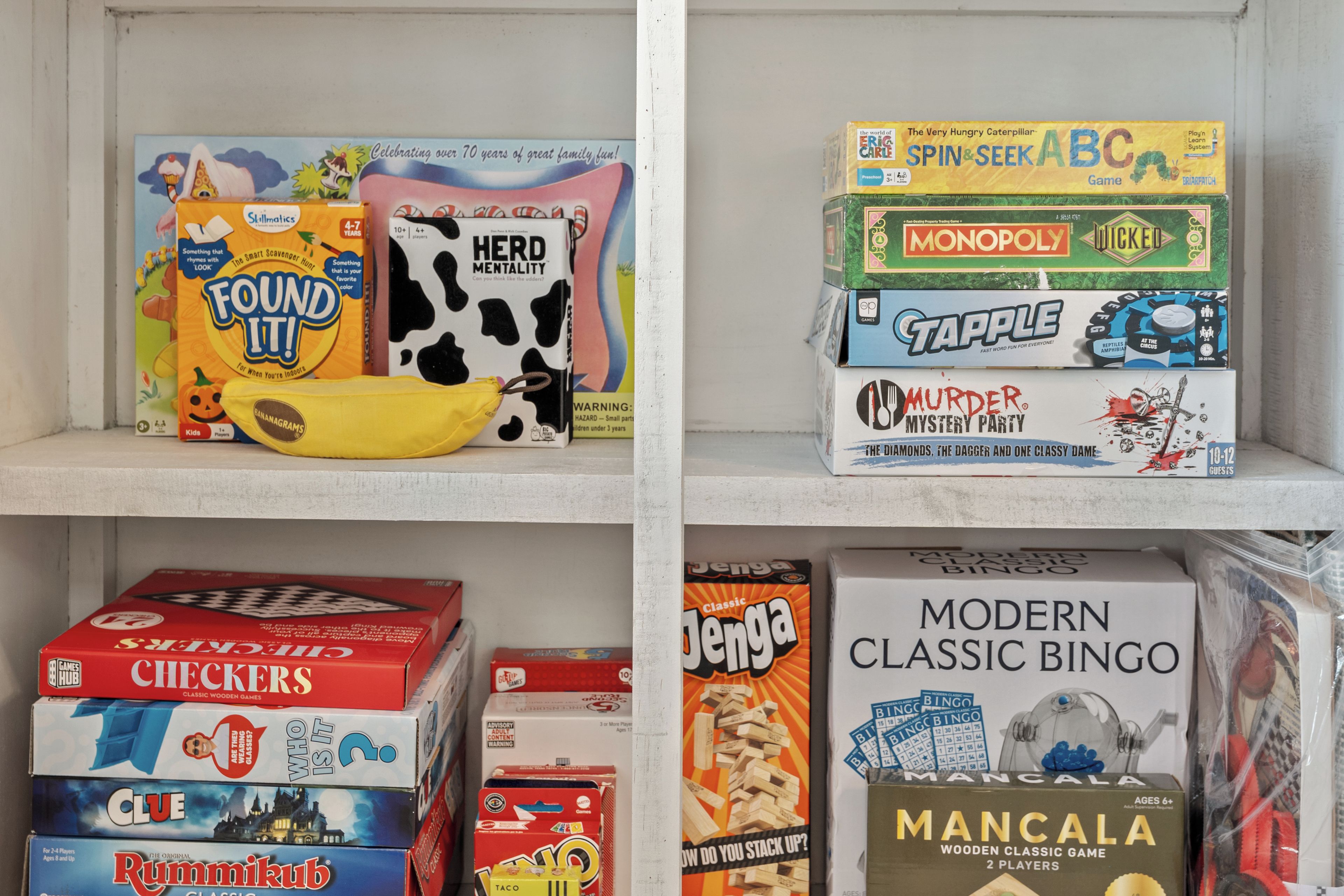En hylla med olika brädspel, bland annat ”Found It!”, ”Monopoly”, ”Clue”, ”Jenga” och ”Modern Classic Bingo”.