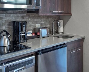 Una cocina moderna con electrodomésticos de acero inoxidable, un tostador y una cafetera.