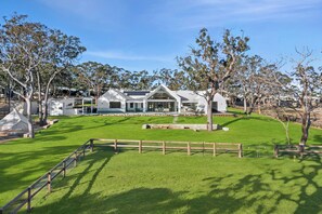 Une maison moderne dotée d’une grande pelouse et d’une clôture en bois.