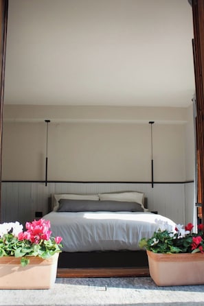A bedroom with a bed, two bedside tables, a headboard, and two potted plants. - Mountain Home, 6 minutes from the cable car, pets allowed, up to 4 guests. (Chiesa In Valmalenco)