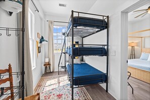 Fun bunk room featuring a multi-level bunk bed with blue bedding, bright windows, coastal accents, and flexible sleeping space for groups. - Galveston 4BR Getaway Game Room Sleeps 12 (Galveston)