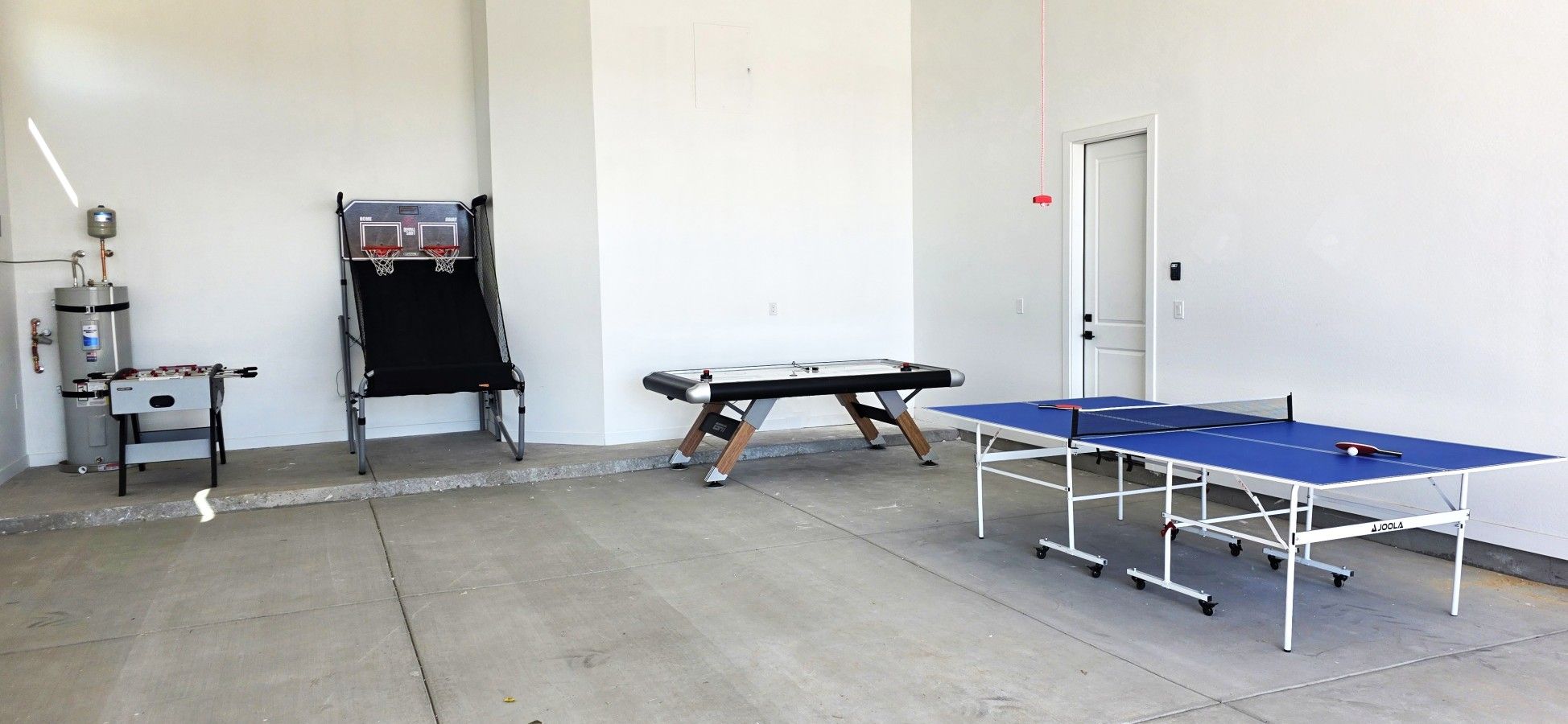 Une pièce équipée d’une table de ping-pong, d’un baby-foot et d’une table de billard.