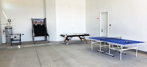 Ein Raum mit Tischtennisplatte, Kicker und Billardtisch.
