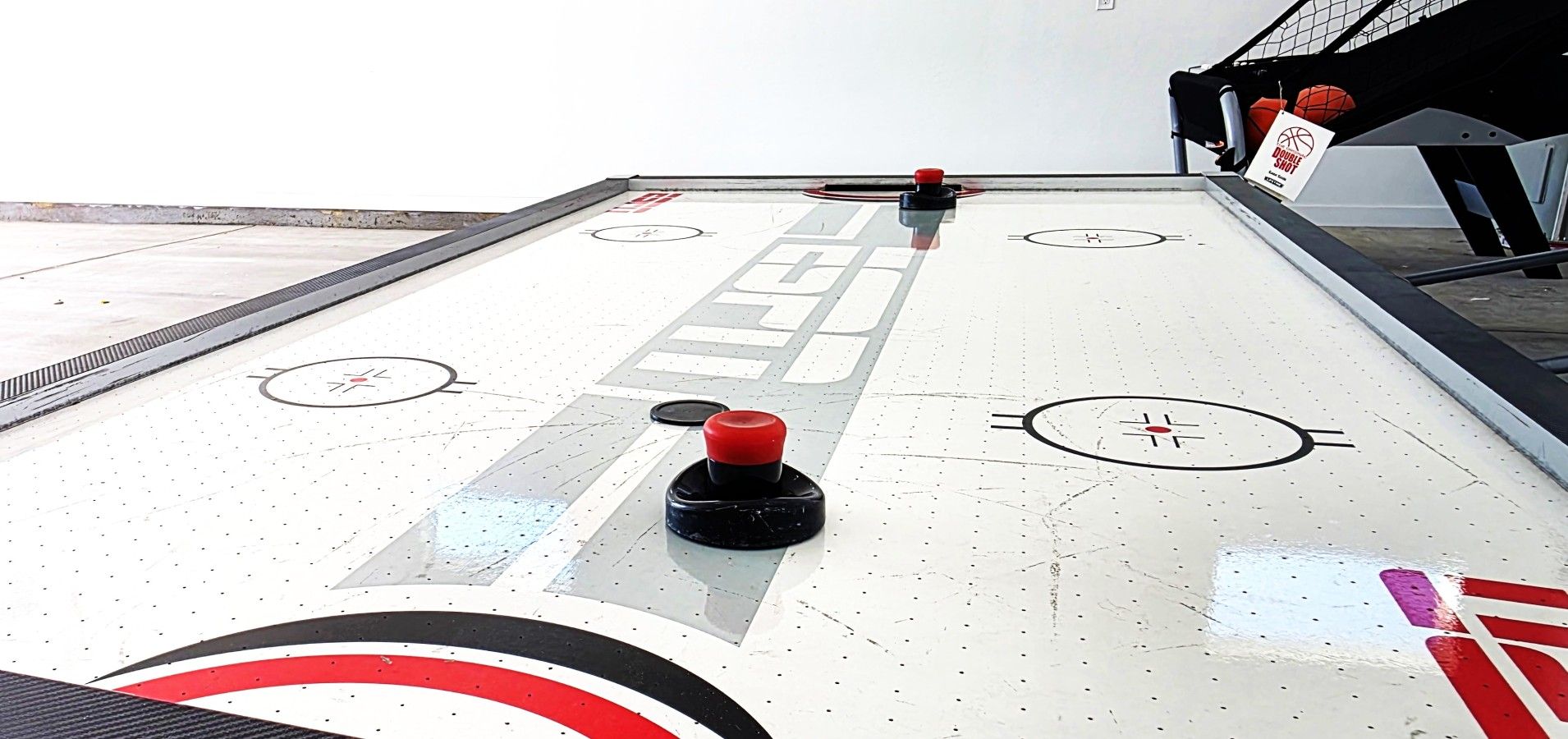 A shuffleboard table with pucks and a 'Double Shot' sign.