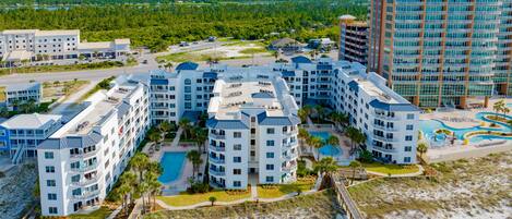 A resort with multiple buildings, a swimming pool, and a beach area.