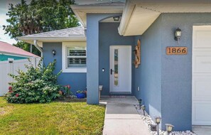 A residential house with a blue exterior, a white garage door, and a number plaque indicating the address. - Cozy home near the beach in Sarasota (Sarasota)