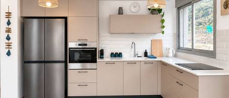 A modern kitchen with a stainless steel refrigerator, double ovens, and a sink.
