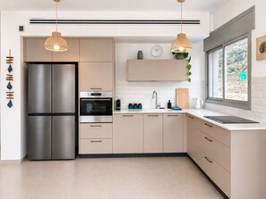 A modern kitchen with a stainless steel refrigerator, double ovens, and a sink.