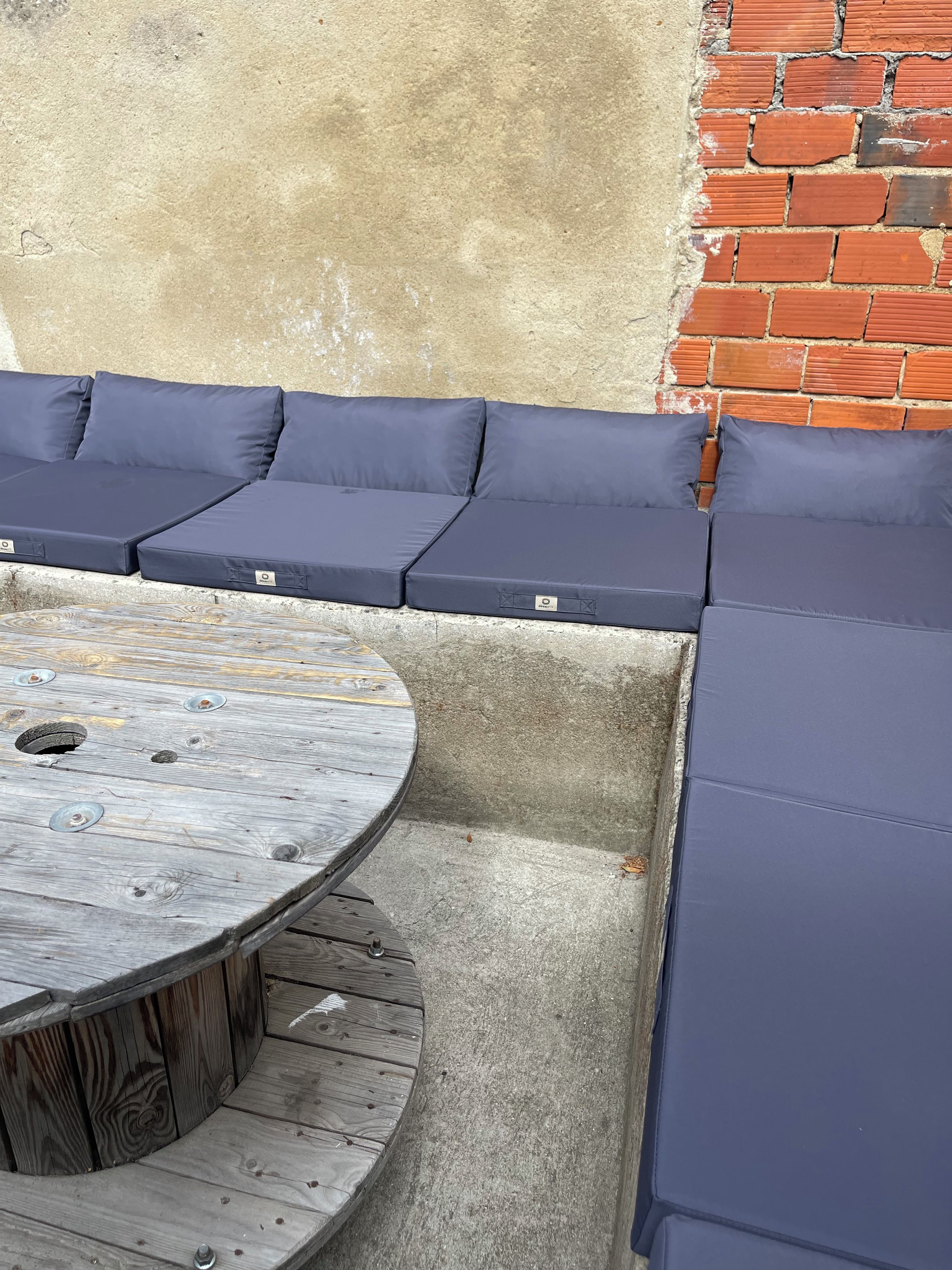A corner seating area with a round wooden table and cushioned benches.
