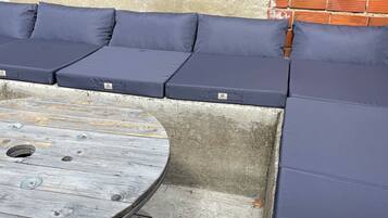 A corner seating area with a round wooden table and cushioned benches.
