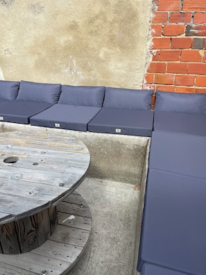 A corner seating area with a round wooden table and cushioned benches.