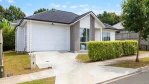 A single-story residential house with a garage, a driveway, and a well-maintained lawn.