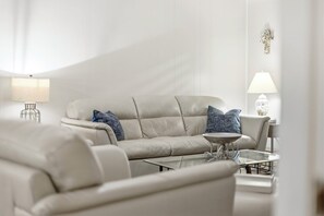 A modern living room with a sofa, armchairs, a coffee table, and two lamps. - Salty Breeze - Cozy 4BR Beach House w/ Private Dock (Sleeps 10) (North Myrtle Beach)