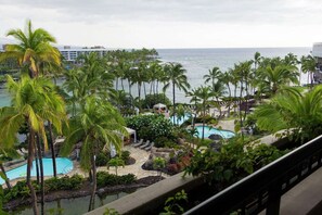 Ett semesterparadis med flera pooler, palmer och utsikt över havet.