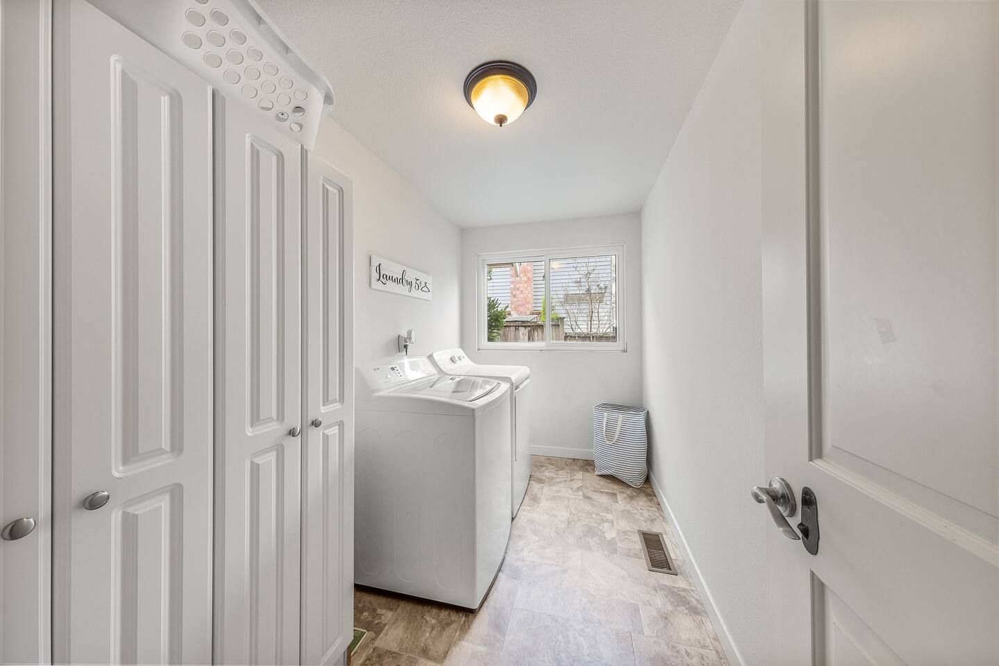 A laundry room with a washing machine, a drying rack, and a sign that reads 'Laundry 5'.