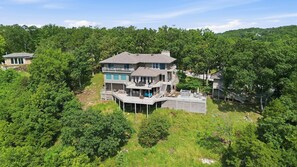 A two-story house with a balcony, a pool, and a deck area. - 7BR Lake View Escape, Hot Tub, Lake Views & Game Room (Lake Ozark)