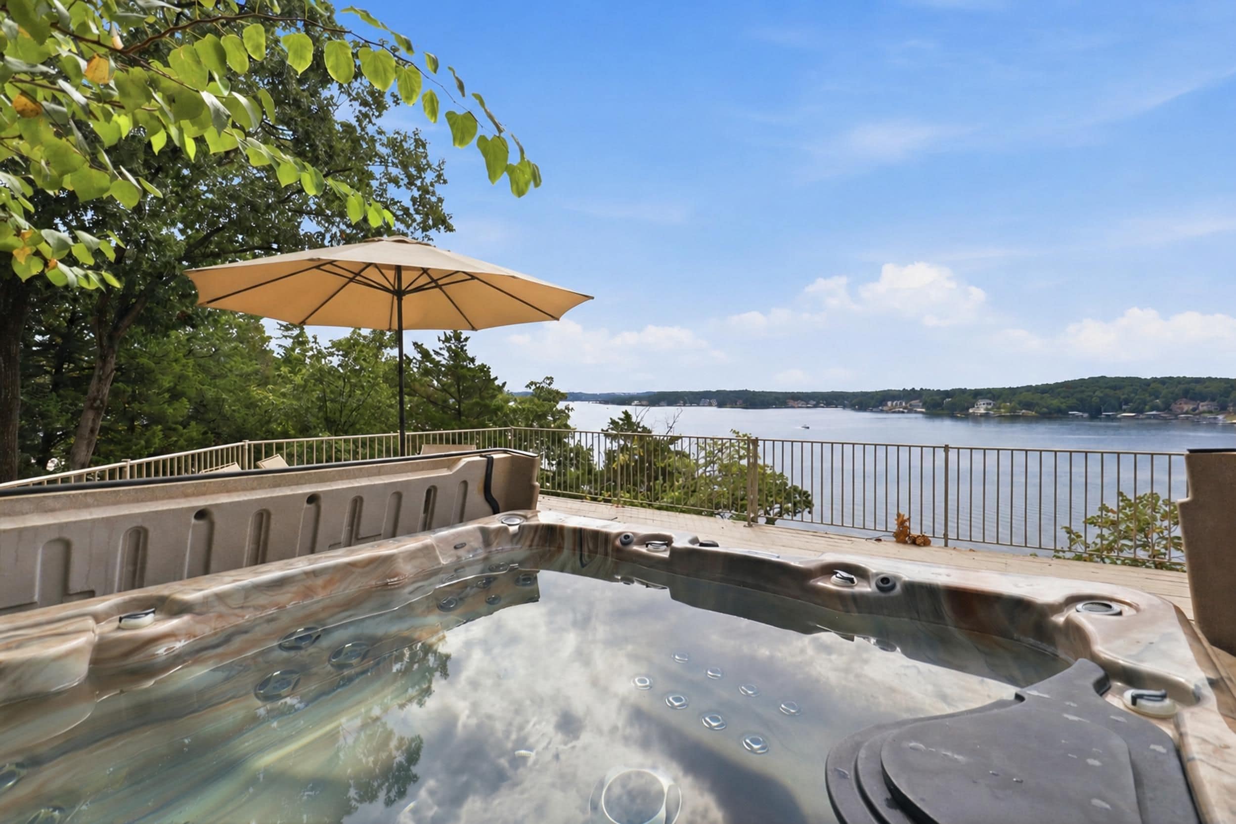 Un jacuzzi con vistas a un lago y una orilla lejana.