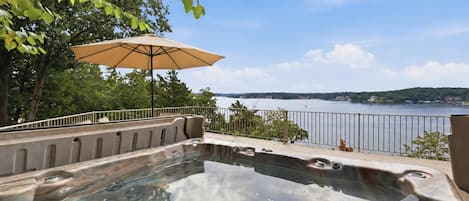 A hot tub with a view of a lake and a distant shoreline.