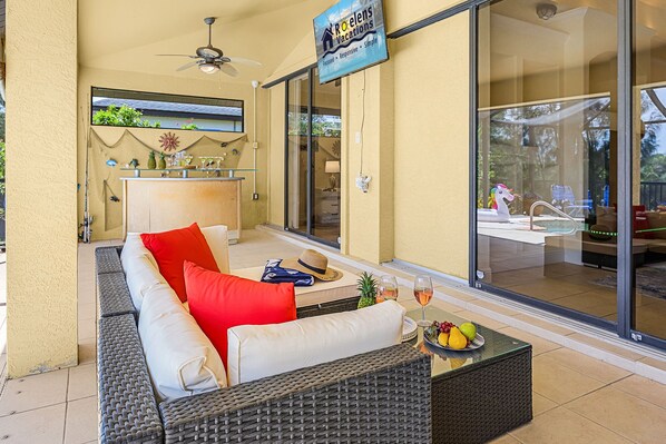 Uma área externa com assentos, incluindo um sofá e uma mesa, e uma placa para Roelens Vacations.