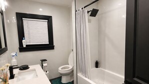 Une salle de bain avec des toilettes, un lavabo et une douche.
