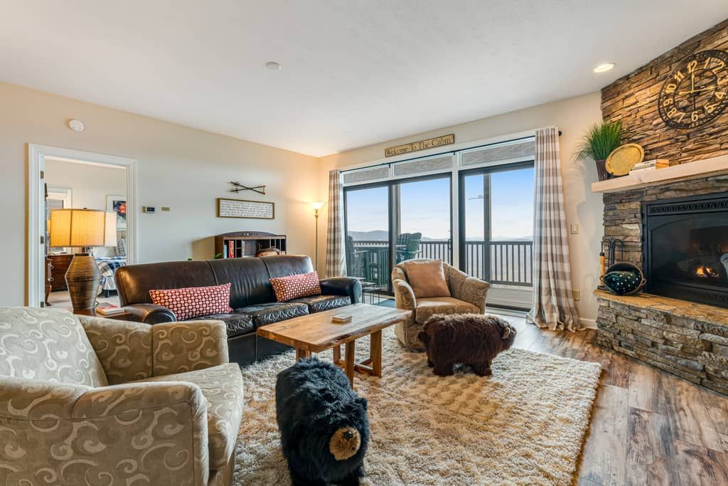 A living room with a fireplace, a sofa, a coffee table, and a rug.