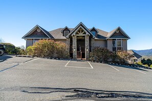 A two-story house with a stone entrance, a garage, and a driveway. - A Sweet Escape: 2br Condo in The Reserve on Sugar Mtn - Long Range Views! (Sugar Mountain)