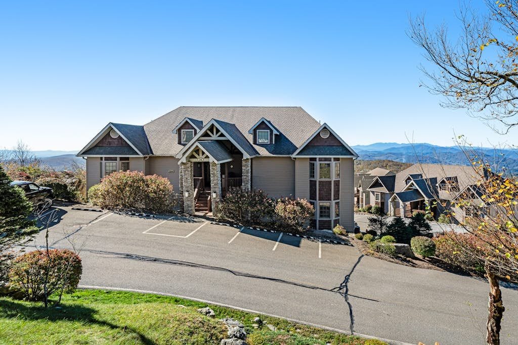 A two-story house with a garage, a driveway, and a clear view of the surrounding landscape.