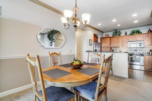 A dining area with a wooden table, chairs, and a chandelier. - A Sweet Escape: 2br Condo in The Reserve on Sugar Mtn - Long Range Views! (Sugar Mountain)